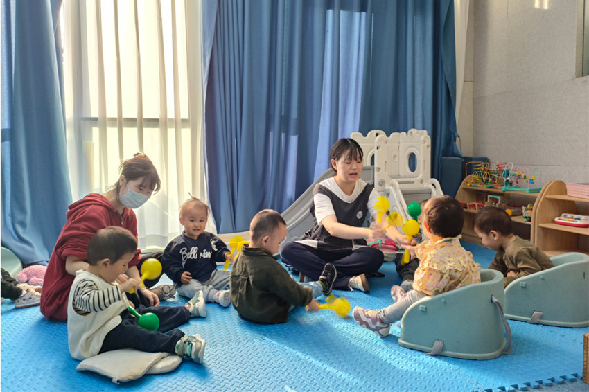 内江彩色鱼小幼芽托育中心，幼师陪伴幼儿玩耍。内江融媒供图