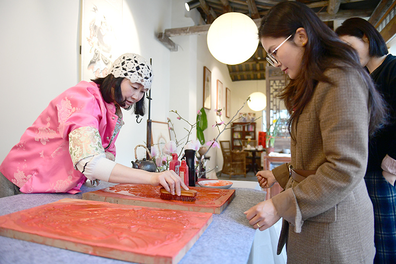 王官玲向游客展示制作年画过程。绵竹市融媒体中心供图